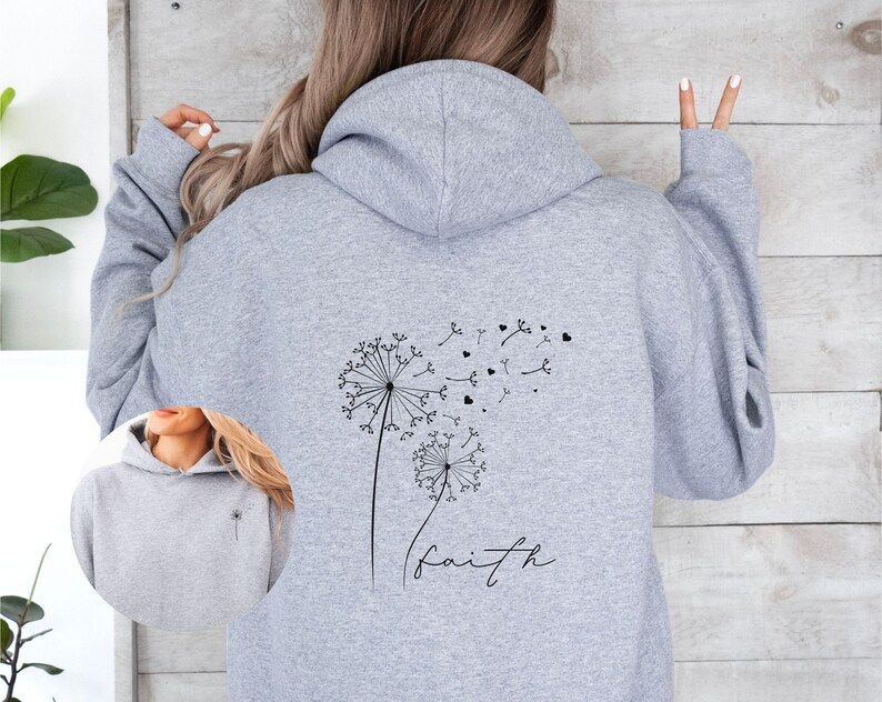 Pu&ograve; includere: Felpa con cappuccio grigia con un design a dente di leone e la parola "faith" stampata sul retro.