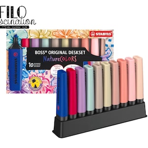 May include: A Stabilo Boss Original Deskset NatureColors containing 10 highlighters in a black plastic stand. The set includes various muted tones like blue, red, purple, green, beige, and pink. The packaging features floral graphics and text.