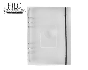 May include: A clear plastic binder with a black elastic closure and a heart-shaped cutout on the front. The binder has six silver rings and the text "FILO fascination" is printed on the front.