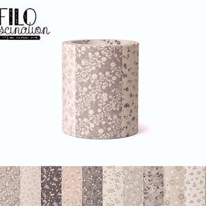 Könnte beinhalten: Eine Rolle dekoratives Washi-Tape mit einem floralen Muster in Beige-, Grau- und Weißtönen. Das Klebeband ist zylindrisch und trägt den Text "FILO fascination" in schwarzer Schrift.