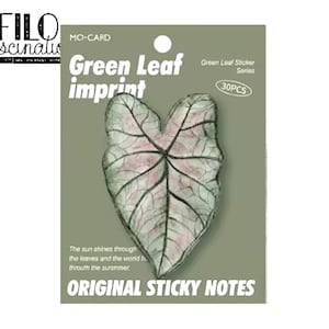 Könnte beinhalten: Eine Packung mit 30 Haftnotizen mit grünem Blattmotiv. Die Notizen zeigen ein großes, weißes und rosa Blatt mit einem grünen Adernmuster. Der Text auf der Packung lautet "Green Leaf Imprint" und "Original Sticky Notes".