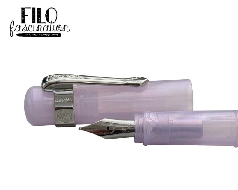 May include: A lavender-colored fountain pen with a silver clip and nib. The pen is partially disassembled, with the cap and body separated. The text "FILO fascination" is in the upper left corner.