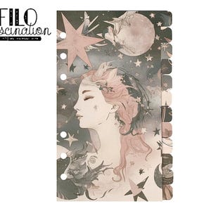 Pode incluir: Uma capa de agenda Filofax com um design caprichoso que apresenta uma mulher com cabelos soltos, estrelas e uma lua. O texto "FILO fascination" está impresso na parte superior da capa.