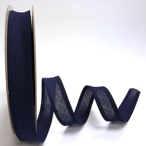 May include: A roll of dark blue bias binding, a type of fabric trim used for finishing edges of fabric.