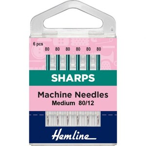 May include: A pack of 6 Sharps machine needles, size 80/12, for sewing. The needles are packaged in a clear plastic container with a pink and green label. The label says "Sharps Machine Needles Medium 80/12" and "Hemline".