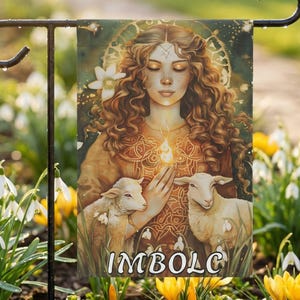 May include: A rectangular garden flag featuring an illustration of a person with long wavy brown hair, holding a small flame, flanked by two lambs. The background includes a golden circular pattern and white flowers. The text IMBOLC is at the bottom.