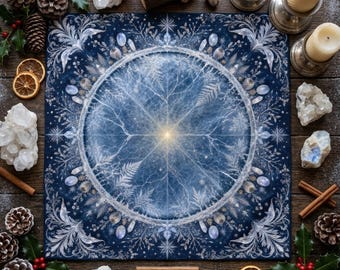 Puede incluir: Un paño de altar cuadrado de color azul oscuro con un diseño de mandala circular blanco central con intrincados patrones de escarcha, helechos y estrellas. La tela mide 25,4 cm por 25,4 cm y está rodeada de piñas, cristales, velas y rodajas de naranja.