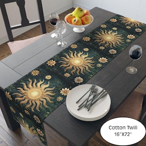May include: A dark green cotton twill table runner featuring a repeating sun and floral design in gold and cream. The runner is 16 inches wide and 72 inches long. The table is set with plates, silverware, and wine glasses.