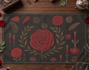May include: A dark gray altar cloth featuring a large red rose surrounded by botanical and geometric illustrations. The design includes red candles, feathers, and crystals. The cloth is set on a wooden surface with other ritual items.