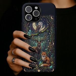 May include: A dark blue phone case featuring a forest scene with a deer, fox, and owl. The design includes a crescent moon, stars, and mushrooms. The case has a glossy finish and is held by a hand with black nail polish.