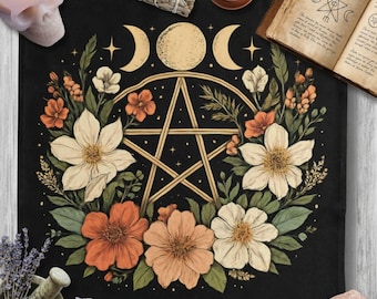May include: Black altar cloth featuring a floral design with a gold pentagram, crescent moons, and stars. The flowers are in shades of orange, cream, and white, surrounded by green leaves. The cloth is a square shape.