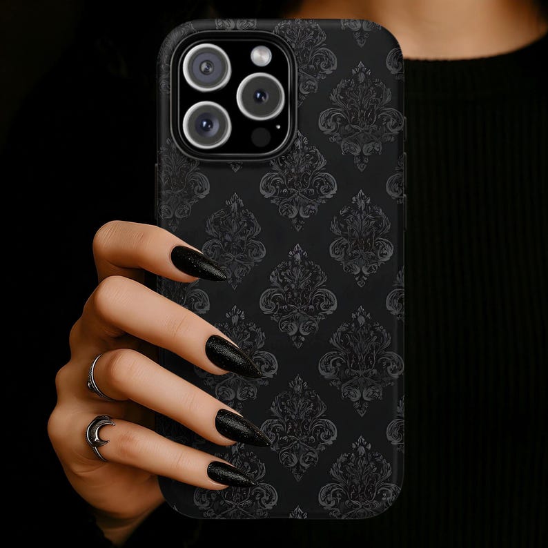 Black phone case featuring a subtle dark gray damask pattern with ornate gothic-style flourishes on a matte black background.