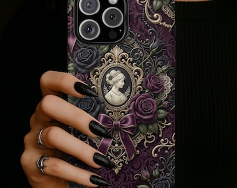 Könnte beinhalten: Eine Handyhülle mit einem dunkelvioletten Hintergrund mit einem viktorianischen Cameo-Porträt, lila und schwarzen Rosen und aufwendigen goldenen Filigranarbeiten. Unten befindet sich eine lila Schleife. Das Gehäuse hat ein Kameramodul mit drei Objektiven.