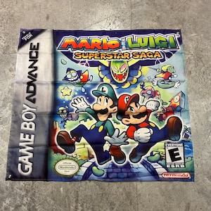 May include: A blue and green banner with the text "Mario & Luigi Superstar Saga" and images of Mario and Luigi. The banner is for the Game Boy Advance.