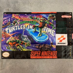 May include: A rectangular banner featuring the Teenage Mutant Ninja Turtles IV: Turtles in Time video game. The banner has a vibrant, colorful design with the game's logo and characters. The Super Nintendo Entertainment System logo is also visible.