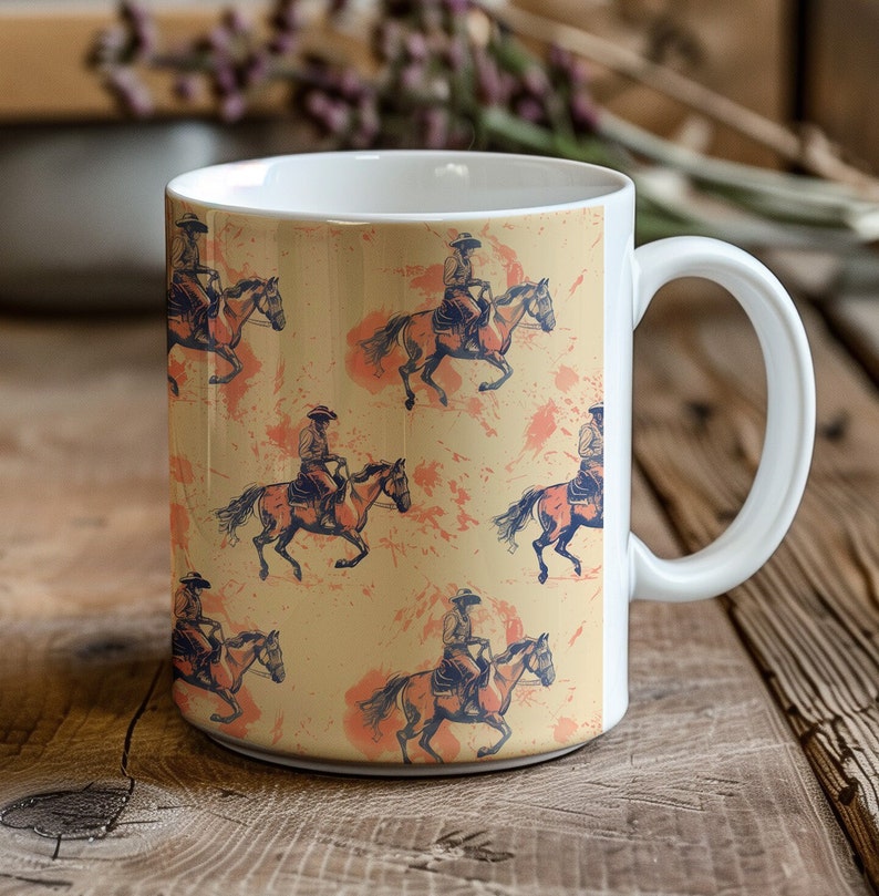 Puede incluir: Taza de cer&aacute;mica blanca con un patr&oacute;n repetido de vaqueros montando caballos sobre un fondo amarillo con salpicaduras naranjas.