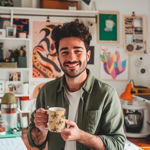 Puede incluir: Una persona sosteniendo una taza de cer&aacute;mica blanca con fondo amarillo y un patr&oacute;n de caballos y jinetes. La taza mide 9,5 cm de alto y 7,6 cm de ancho.