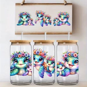 Könnte beinhalten: Klare Glasbecher mit Bambusdeckeln und Strohhalmen, die eine farbenfrohe Illustration einer Mutter-Meeresschildkröte und einer Baby-Meeresschildkröte mit Blumenkränzen zeigen. Ein passender Druck hängt darüber.