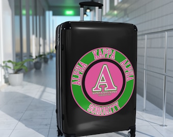 Niedlicher Alpha Kappa Sorority-Koffer – auch bekannt als rosa und grüner Soror-Reisekoffer mit griechischen Buchstaben und rundem Design.