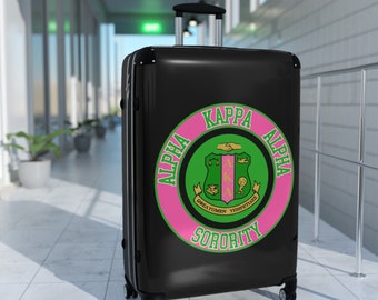 Niedlicher Alpha Kappa Sorority-Koffer – auch bekannt als rosa und grüner Soror-Reisekoffer mit griechischen Buchstaben und rundem Design.