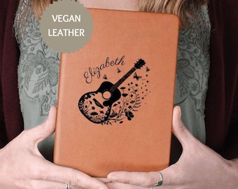May include: A brown vegan leather journal with the name "Elizabeth" and a black silhouette of a guitar with butterflies and floral accents.
