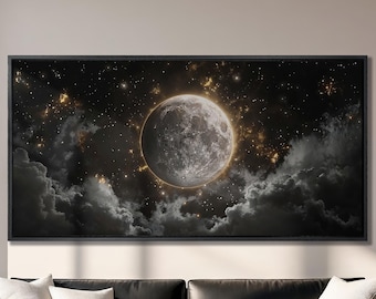 May include: A black framed canvas print of a large, glowing moon in a dark, starry sky with clouds. The moon is a light gray color with a golden halo around it.