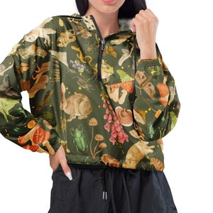 May include: A green hooded jacket with a zip fastening and a drawstring waist. The jacket features a colourful print of various woodland creatures, including mushrooms, butterflies, frogs, and beetles.