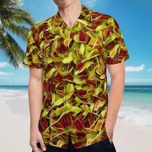 May include: A short-sleeved button-up shirt with a tropical print featuring red and green leaves. The shirt has a collared neckline and a button closure.
