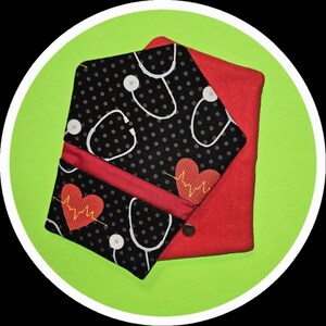 May include: A medical-themed case with a black polka-dot pattern featuring white stethoscopes. The case has a red interior and a red heart with a heartbeat design. A small snap closure secures the case.