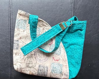 Tulip shaped handbag with Paris postal motif.  11 inches wide by 9 inches tall. Does not include lanyard.