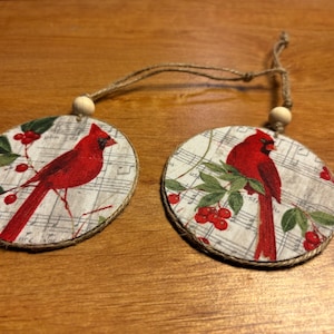 "Handgefertigte Weihnachtsanhänger ""Kardinal""." Stoff auf Holz. Jede Seite hat ein anderes Kardinalbild mit Musik, Beeren und Grünzeug. 3 cm.