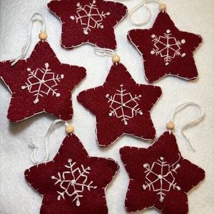 Handcrafted, felt star Christmas ornament with hand embroidered snowflakes and wooden bead. Each handmade ornament is slightly unique.