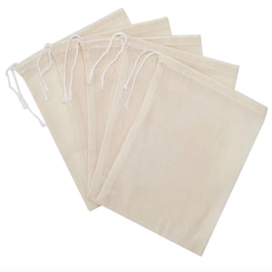 May include: Five beige muslin drawstring bags are arranged on a white background. Each bag has a rectangular shape with a white drawstring closure at the top. The bags are made of a natural, unbleached fabric.