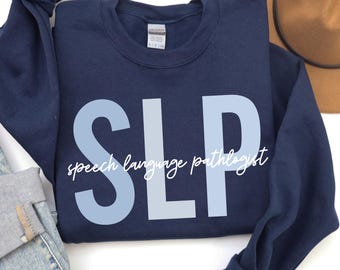 May include: Navy blue sweatshirt with the text "SLP speech language pathologist" in white and light blue lettering.