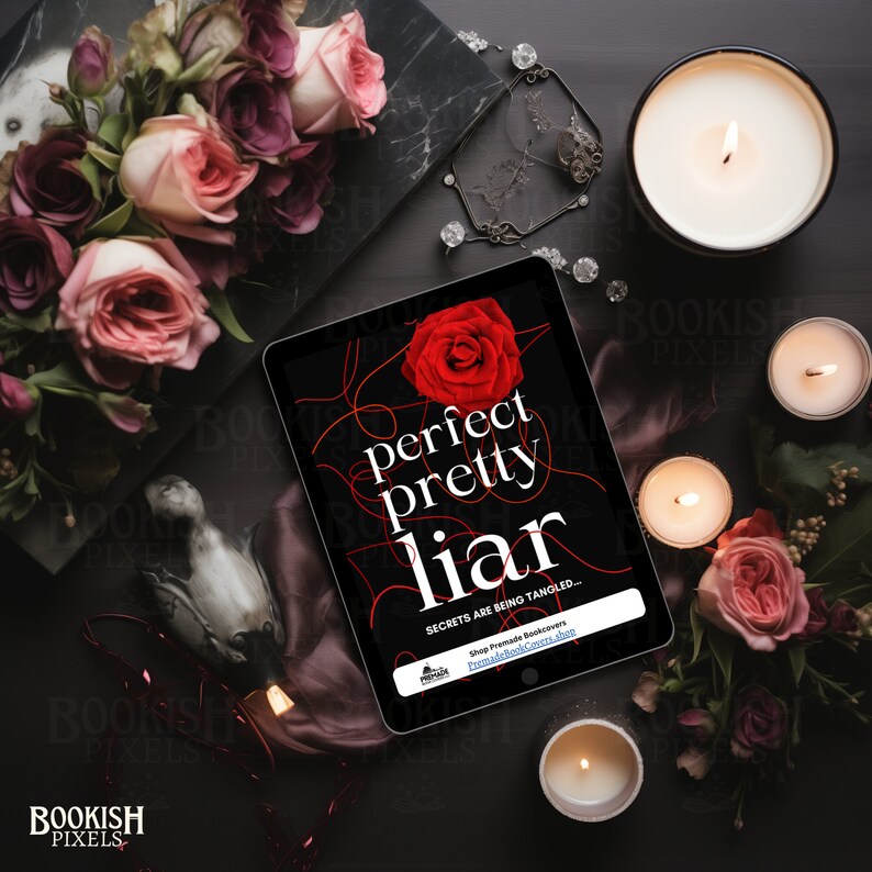 May include: A tablet computer displaying a book cover with the title "perfect pretty liar" in red text. The cover features a red rose and a tangled red string design. The text "SECRETS ARE BEING TANGLED..." is also visible on the cover. The tablet is surrounded by candles, roses, and other decorative items.