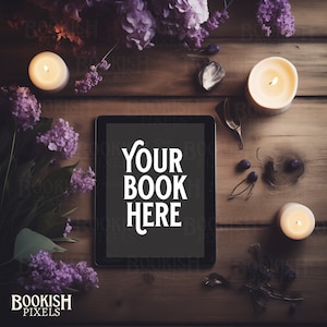 May include: A black tablet computer with a white screen that says "Your Book Here" on a wooden table with candles, flowers, and other decorative items.