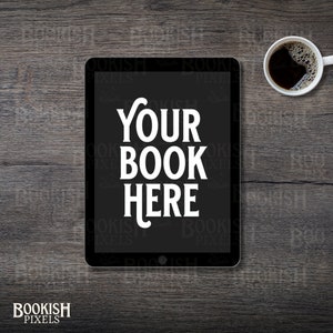May include: A black tablet computer with a white screen displaying the text "YOUR BOOK HERE" on a dark wood surface. A cup of coffee is in the upper right corner of the image.
