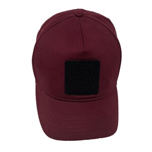 Burgundy cotton 5 panel hat with removable patch panel, adjustable closure and bold color.