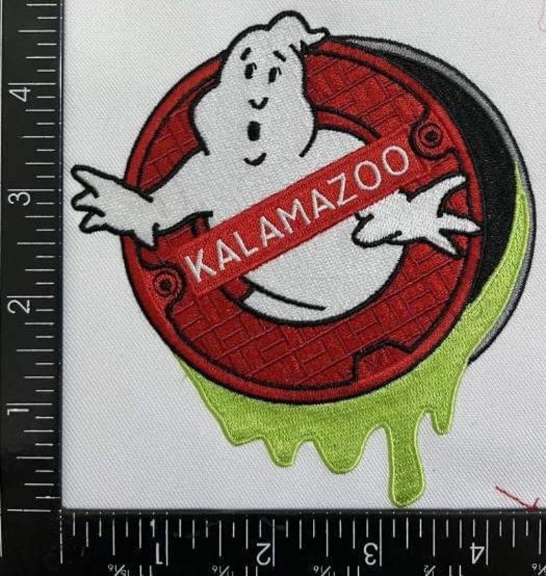 Peut inclure: Un patch brod&eacute; rouge et blanc avec une figure de fant&ocirc;me et le texte "KALAMAZOO" dans une banni&egrave;re rouge. Le fant&ocirc;me est entour&eacute; d'une bordure verte en forme de slime.