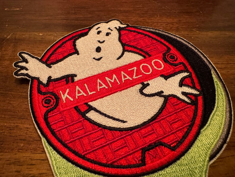 Peut inclure: Un patch brod&eacute; rouge et noir repr&eacute;sentant un fant&ocirc;me blanc avec le texte "KALAMAZOO" au milieu.