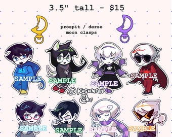 May include: A collection of Homestuck charms, each approximately 3.5 inches tall, featuring various characters. The image includes the text "HOMESTUCK CHARMS" and "SAMPLE" on each charm. The charms have moon clasps and are in the prospit/derse style.