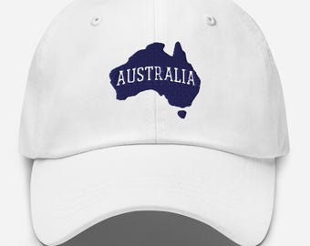 Op de afbeelding: Witte baseballpet met een marineblauwe silhouet van Australië en het woord "AUSTRALIA" in het wit. De pet heeft een gebogen klep en een verstelbare band aan de achterkant.