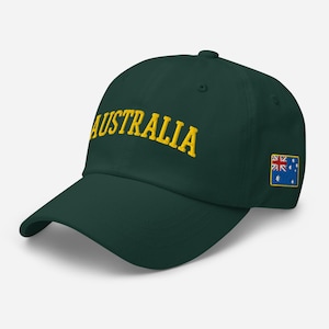 Könnte beinhalten: Dunkelgrüne Baseballkappe mit dem Wort "AUSTRALIA" in Gelb auf der Vorderseite gestickt. Die australische Flagge ist auf der Seite aufgestickt. Die Kappe hat einen gebogenen Schirm und einen verstellbaren Riemen.