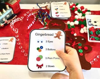 Op de afbeelding: Een feestelijke scène met knutselbenodigdheden met een gingerbread-thema. De afbeelding toont een kaart met de tekst "Gingerbread" en instructies voor het versieren van gingerbreadmannen. Inclusief knopen, pompons en een speelgoedtrein.