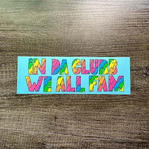 May include: A light blue sticker with the text "IN DA CLUB WE ALL FAM" in colorful, wavy letters.