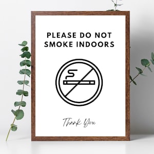 Puede incluir: Un cartel blanco con un marco de madera marrón. El cartel dice "Por favor, no fume en interiores" con un símbolo de prohibido fumar en blanco y negro y las palabras "Gracias" en la parte inferior.