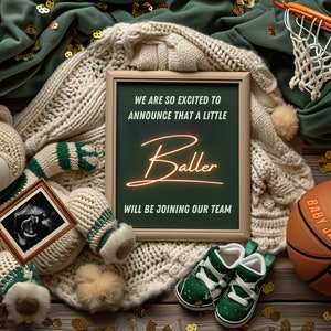 May include: A chalkboard sign with the text "We are so excited to announce that a little Baller will be joining our team."  A teddy bear wearing a green and white striped sweater holds a framed ultrasound image. A basketball with the text "Baby Jacobs 10/24" is on a wooden surface with gold confetti.