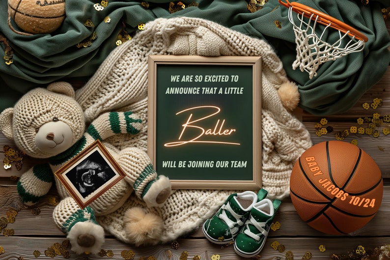 May include: A chalkboard sign with the text "We are so excited to announce that a little Baller will be joining our team."  A teddy bear wearing a green and white striped sweater holds a framed ultrasound image. A basketball with the text "Baby Jacobs 10/24" is on a wooden surface with gold confetti.