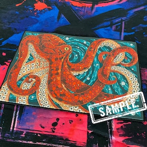 May include: A colorful octopus with a mosaic design in shades of red, orange, and blue. The octopus is on a black background with a white sample label.