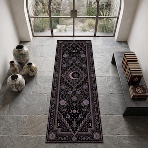 Puede incluir: Una alfombra rectangular tipo pasillero con fondo negro, decorada con intrincados patrones florales morados, fases lunares celestiales y un diseño central de luna creciente. La alfombra tiene un borde ornamental y un motivo detallado.